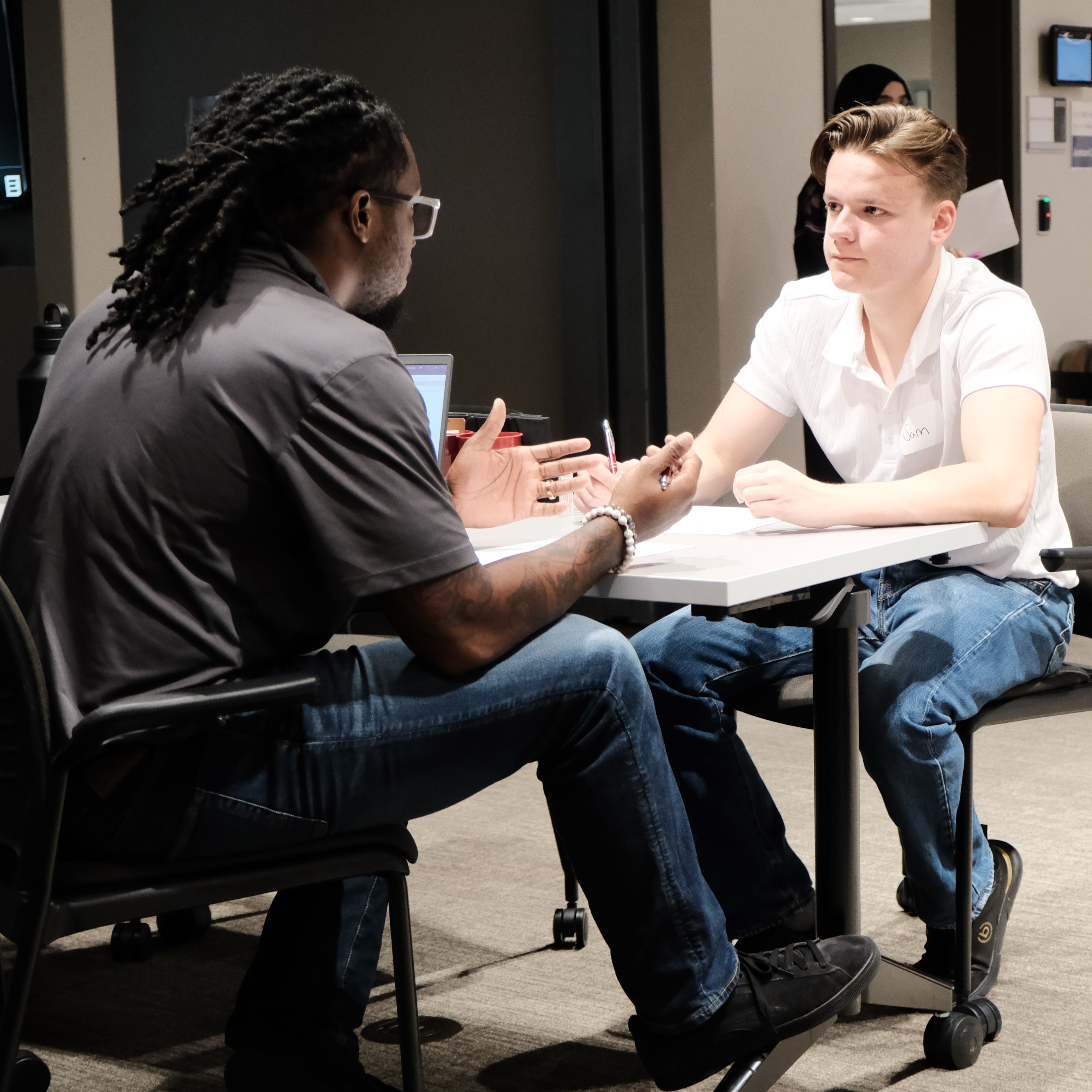 Professional interview scene showing two people having a conversation at a table