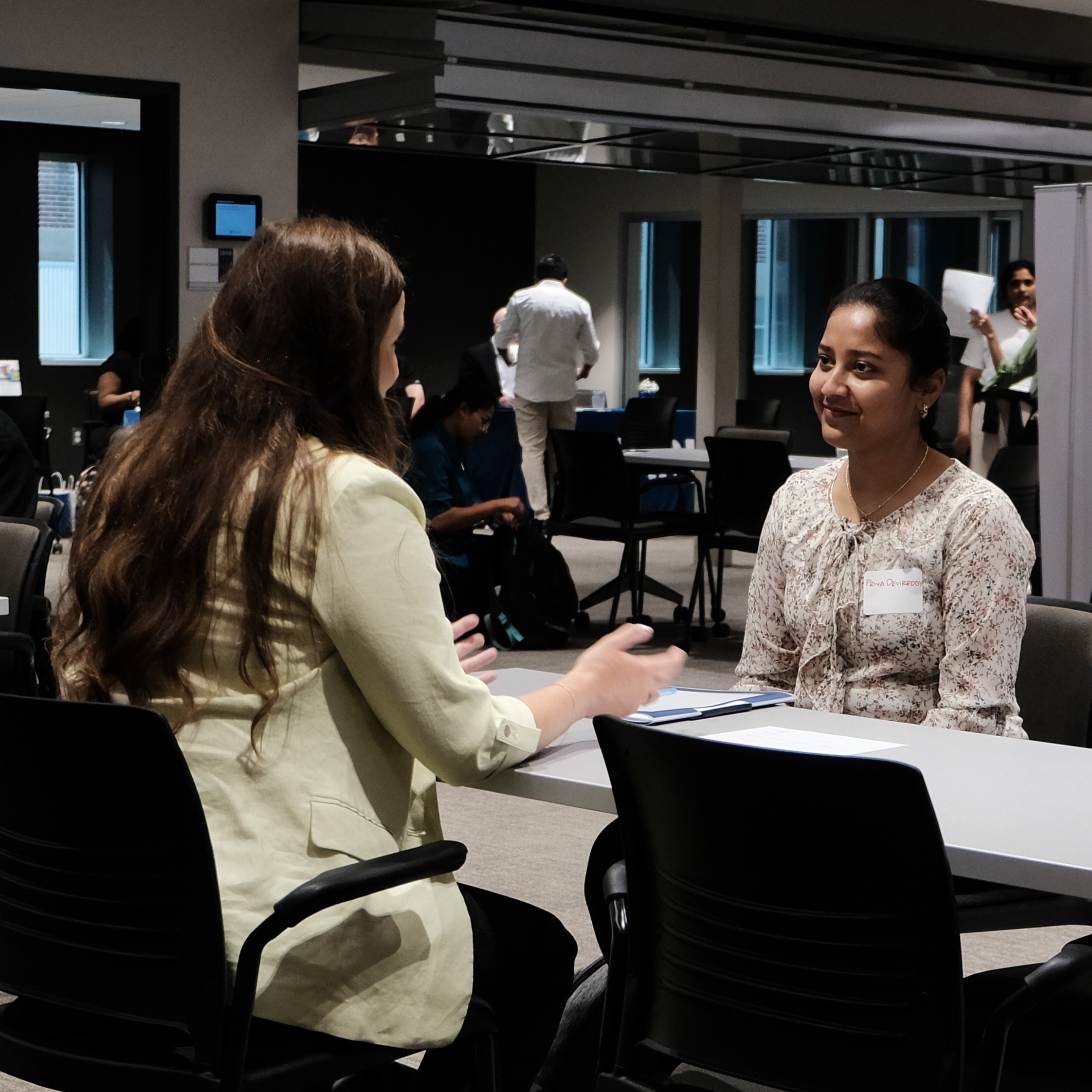 Two women having a professional conversation in a modern office setting